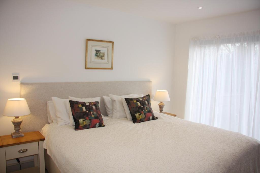 a bedroom with a white bed with pillows and a window at Marshlands Apartment in Lewes