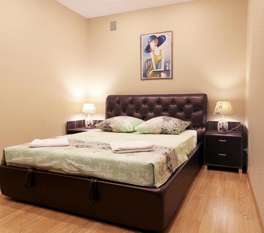 チェレポヴェツにあるАпартаменты в центре Череповцаのベッドルーム1室(大型ベッド1台、革張りのヘッドボード付)