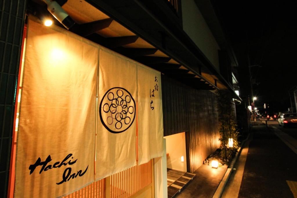 a sign on the side of a building at night at Hachi Inn in Kyoto