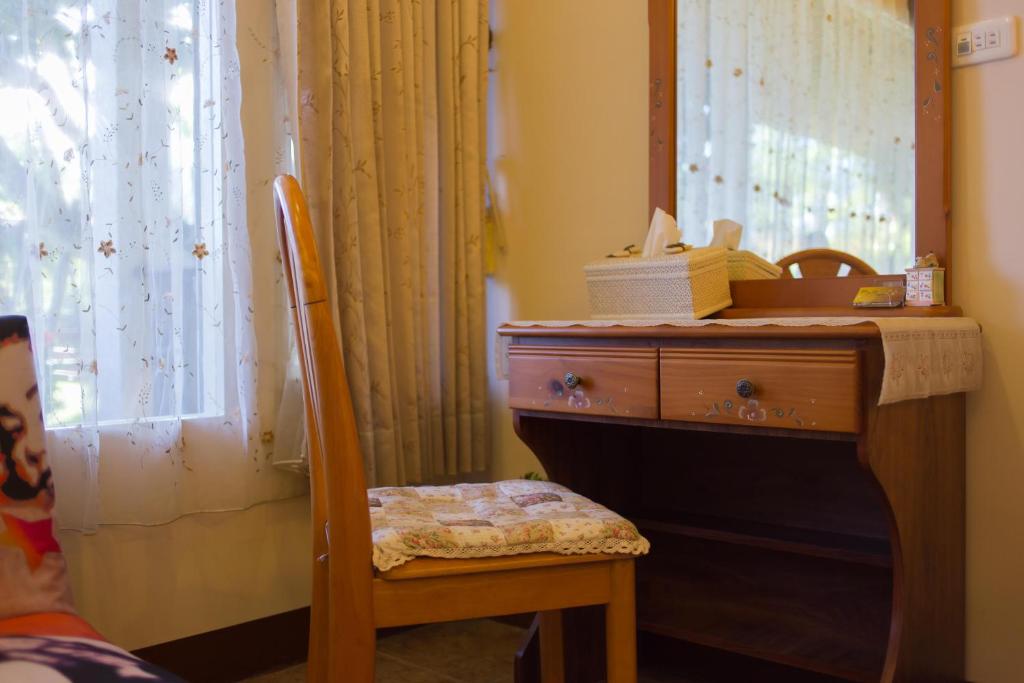 a wooden desk with a chair next to a mirror at Gengmengyuan B&amp;B in Xikou