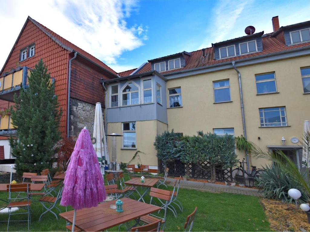 a garden with tables and chairs in front of a building at Spacious Apartment in Ballenstedt Harz near Lake in Ballenstedt