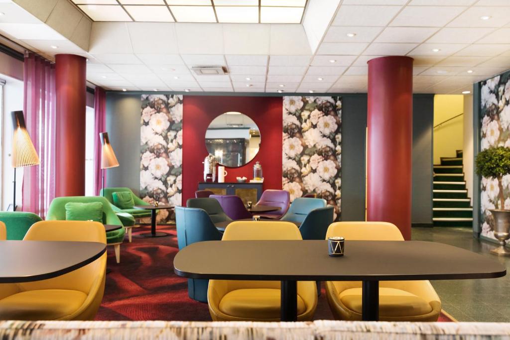 a waiting room with colorful chairs and tables at ProfilHotels Hotel Garden in Malmö