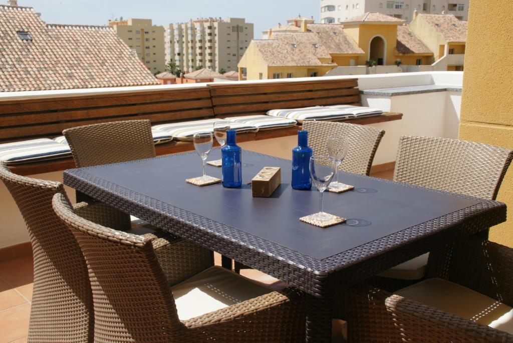 エステポナにあるHomely Apartment (PA4-16)のテーブル(ワイングラス、青いボトル付)