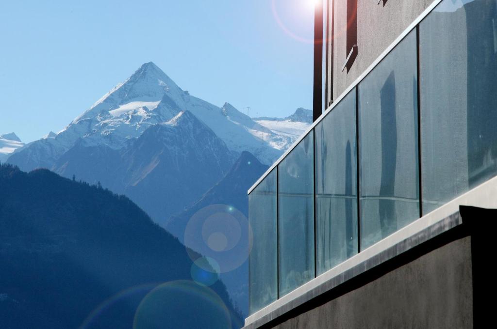 budynek z widokiem na pokrytą śniegiem górę w obiekcie Aparthotel Zell am See (Contactless Check-In) w mieście Zell am See