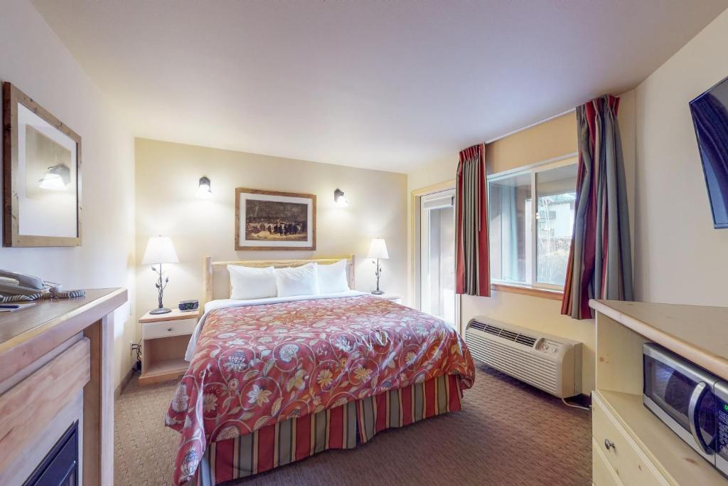 レブンワースにあるAspen Suites 506: The Nestのベッドとテレビが備わるホテルルームです。