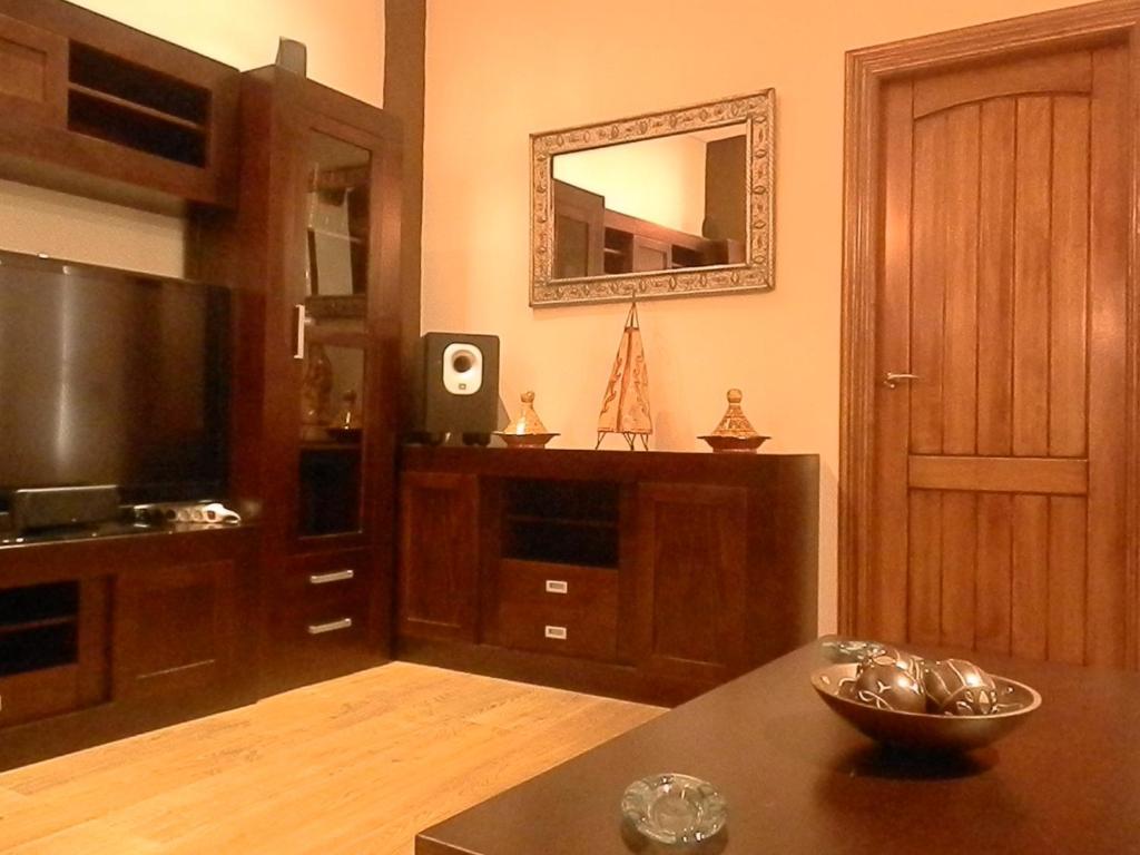 a living room with a table and a mirror at -1-Igual que tu casa, garaje gratis, en el centro in Úbeda