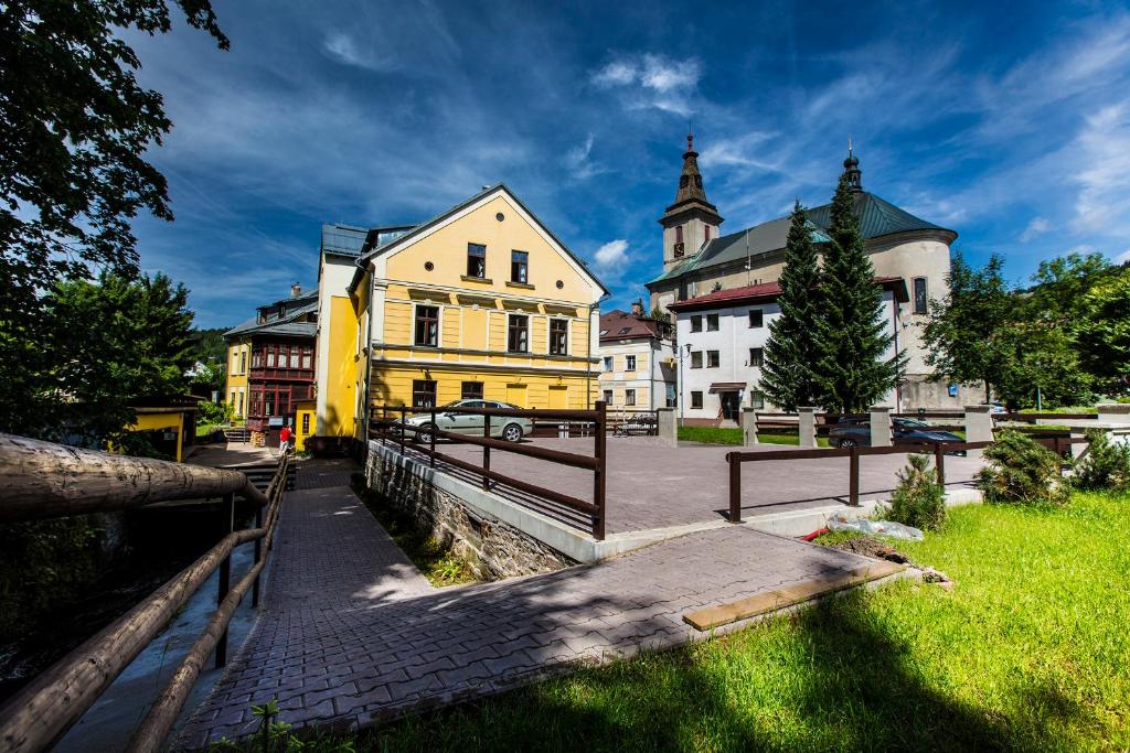 une ville avec un bâtiment jaune et une clôture dans l'établissement YELLOW STREET APARTMENT, à Rokytnice nad Jizerou