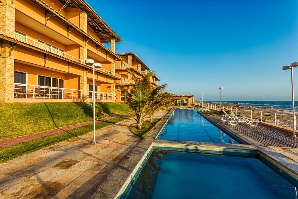 a hotel with a swimming pool next to the ocean at Dream Away Uruaú Beach Residences in Uruau