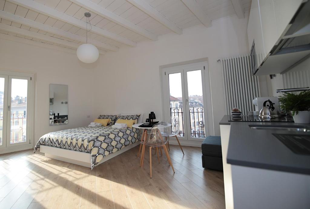 um quarto branco com uma cama e uma mesa em P&D APARTMENTS NAVIGLI VIA CASALE em Milão