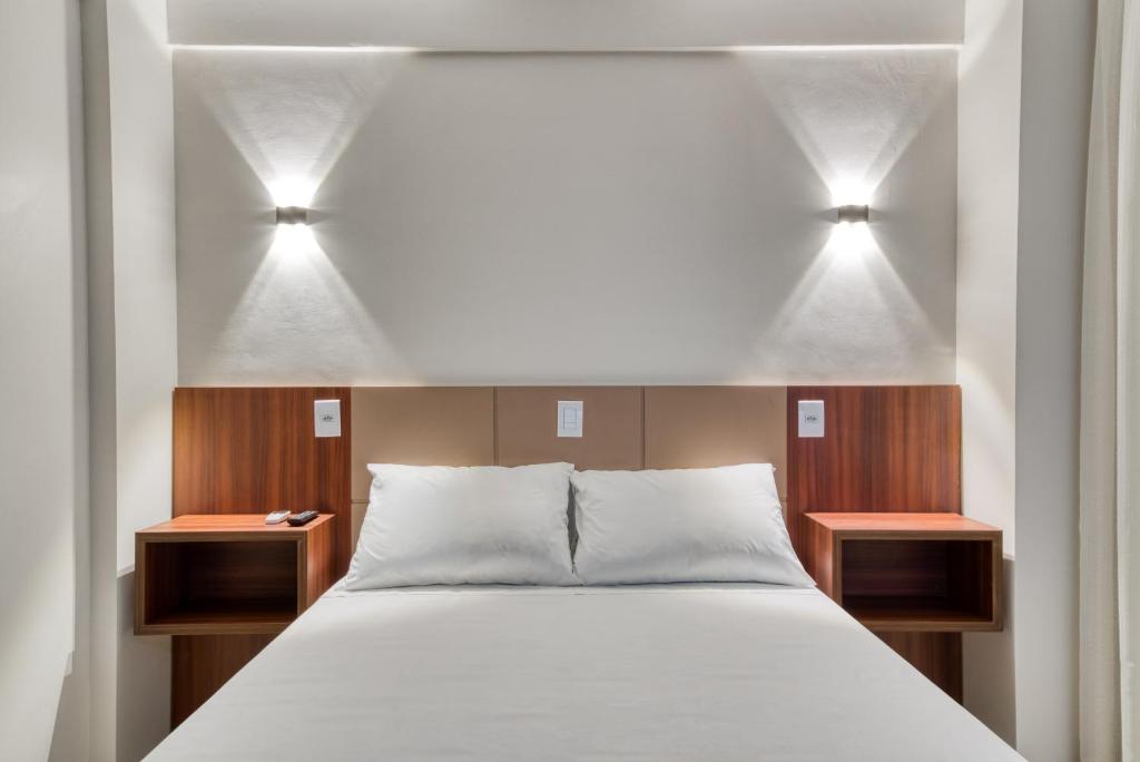 Hotel Sauípe في كاسكافيل: غرفة نوم بها مصباحين فوق السرير