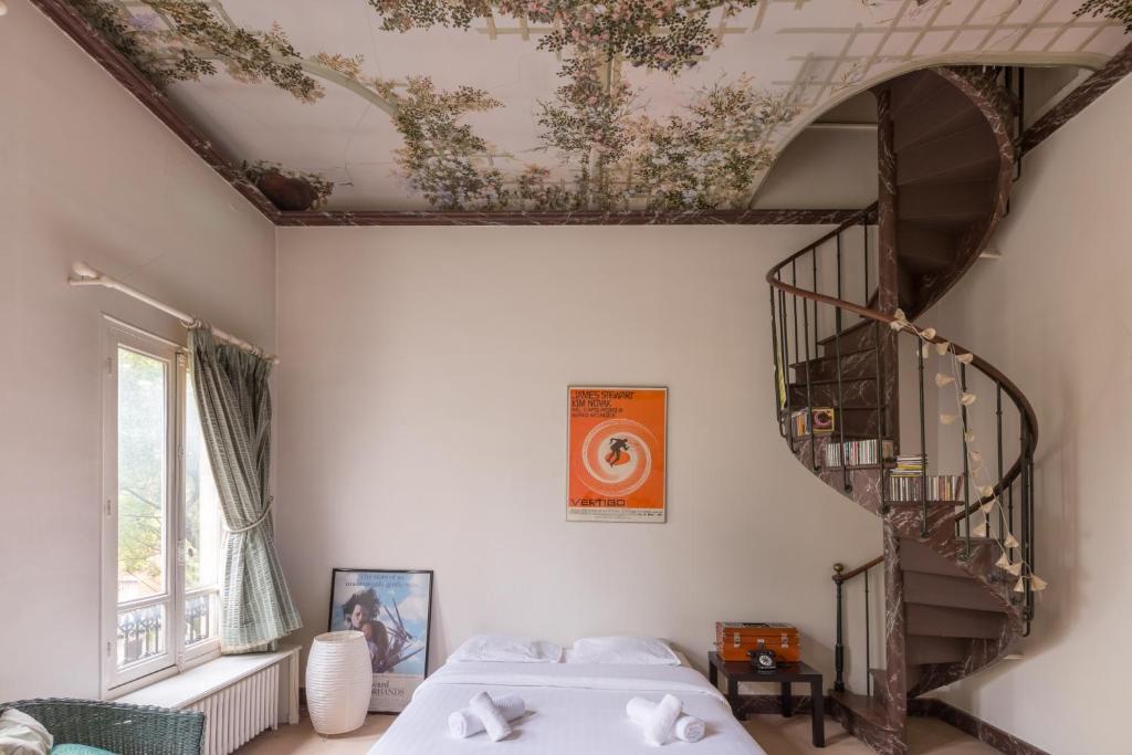 une chambre avec deux lits et un escalier en colimaçon dans l'établissement Veeve - Charming Townhouse near Parc Montsouris, à Paris