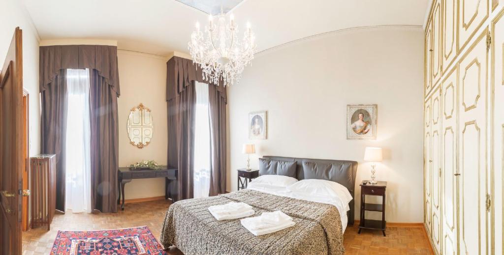a bedroom with a bed and a chandelier at Rialto Canal View With Terrace and Balcony by Wonderful Italy in Venice