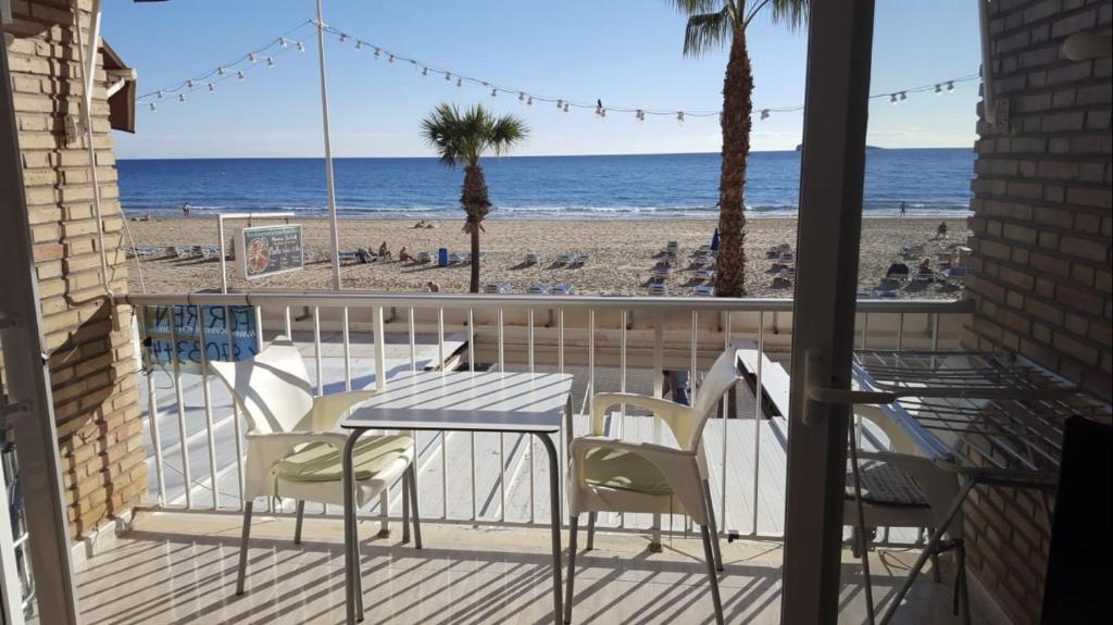 a balcony with a table and chairs and the beach at Los ranchos of the sea in Benidorm
