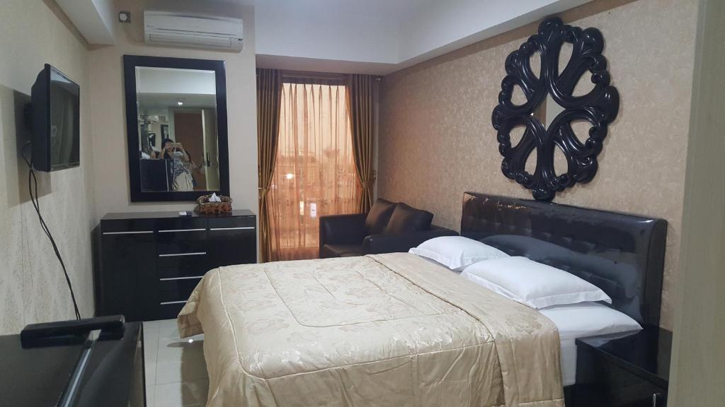 una camera con letto, cassettiera e specchio di Warhol Apartement Lt 15 Jl. Ahmad Yani Simpang 5 Semarang a Semarang