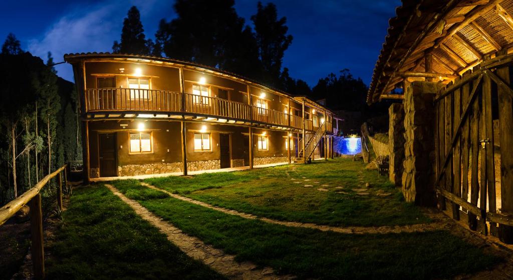 un gran edificio con luces encendidas por la noche en Bamboo Lodge Sacred Valley, en Písac