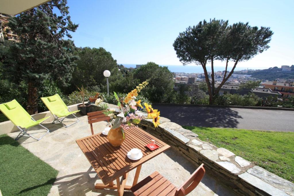 eine Terrasse mit Stühlen und einem Tisch mit Blumen darauf in der Unterkunft Appartement vue mer in Bastia