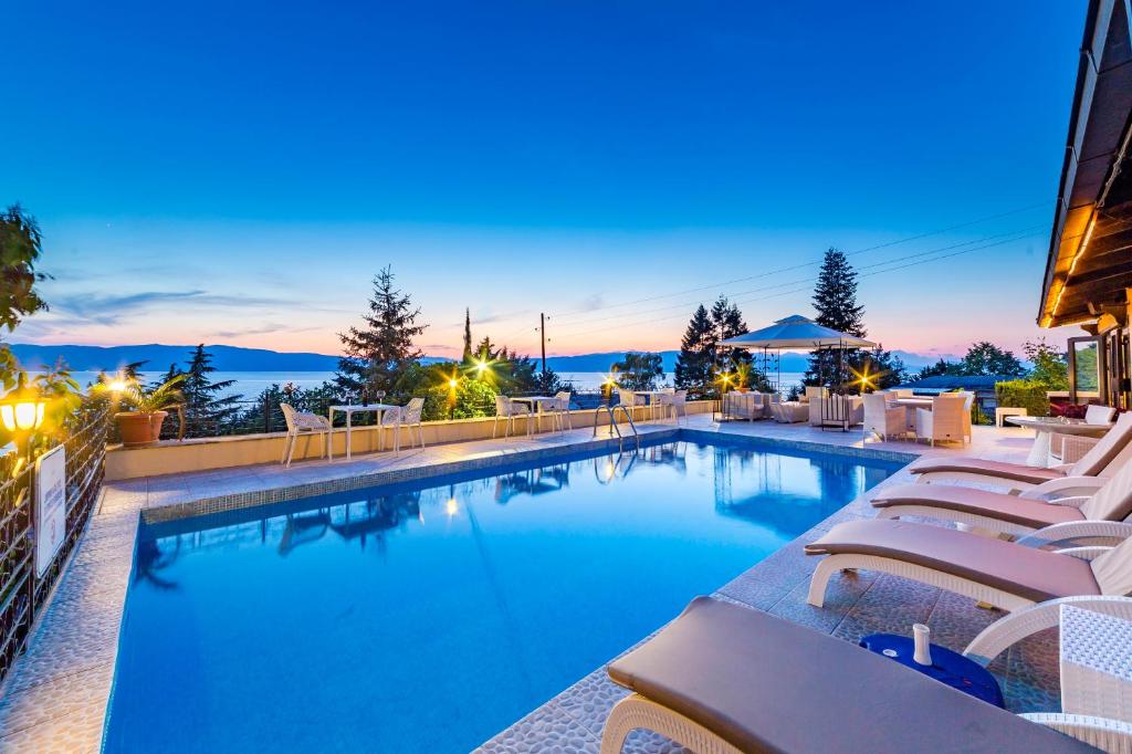 a swimming pool with lounge chairs on a building at Vila Bisera in Ohrid