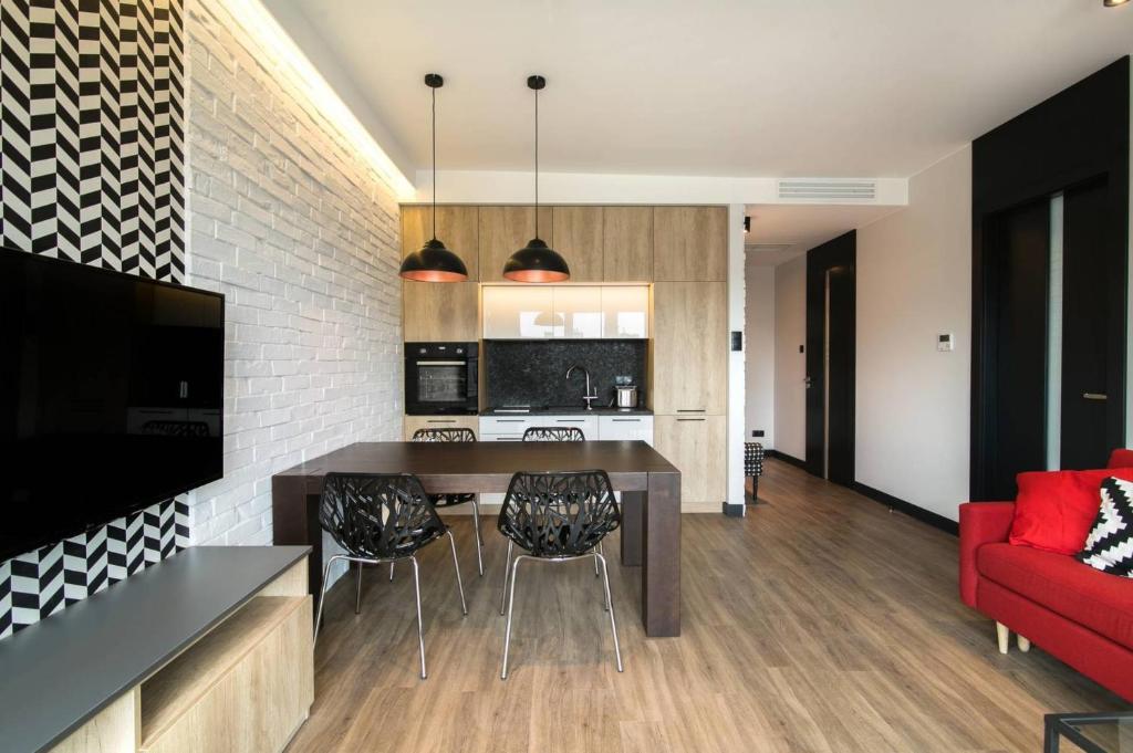 kuchnia i salon ze stołem i krzesłami w obiekcie Montevideo Centrum 15 by Grand Apartments w mieście Sopot