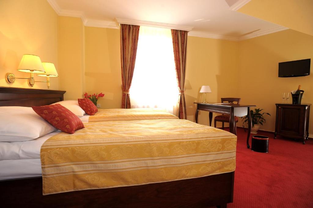 a hotel room with a bed and a window at Hotel U Krále in Jičín