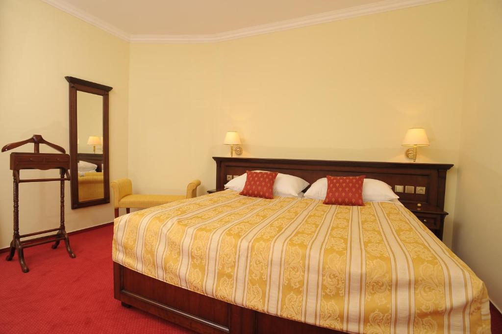 a hotel room with a bed and a mirror at Hotel U Krále in Jičín