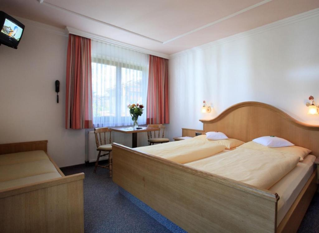 A bed or beds in a room at Pension Lärchenbrunn