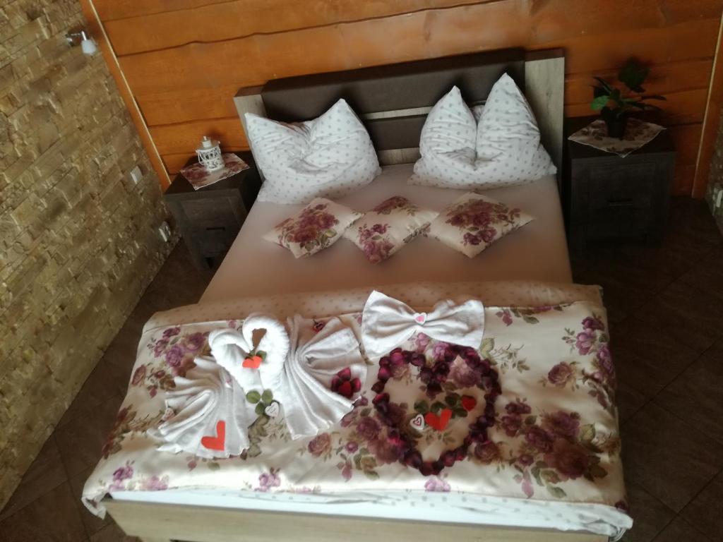 ein Bett mit einem Kleid und Kissen darauf in der Unterkunft Apartmán u Žanety in Ždiar