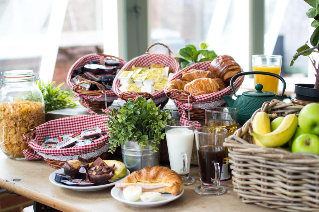 a table topped with baskets of food and bread at Palmers Lodge Swiss Cottage in London