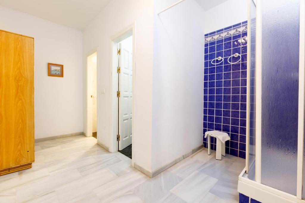 a bathroom with a blue tiled wall at AT Almoraide Rooms Suites in Nerja
