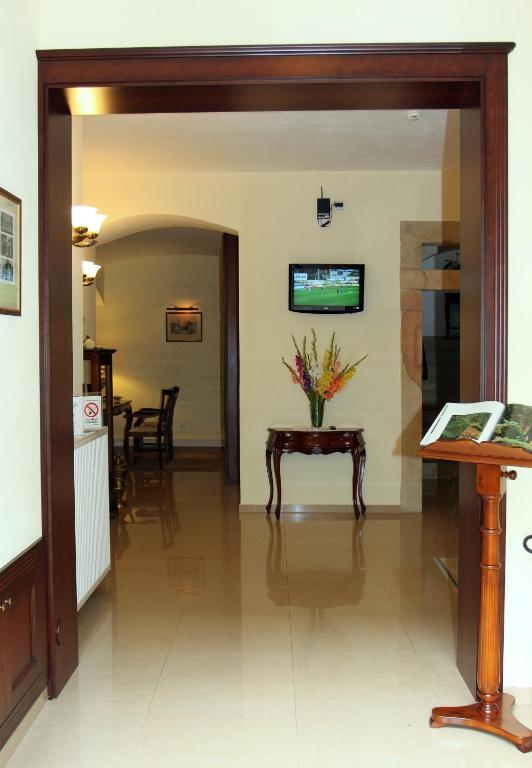 a living room with a table and a tv at Hotel U Krále in Jičín