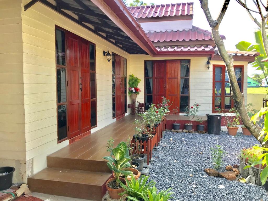 un porche delantero de una casa con plantas en Grandma's House en Nakhon Nayok