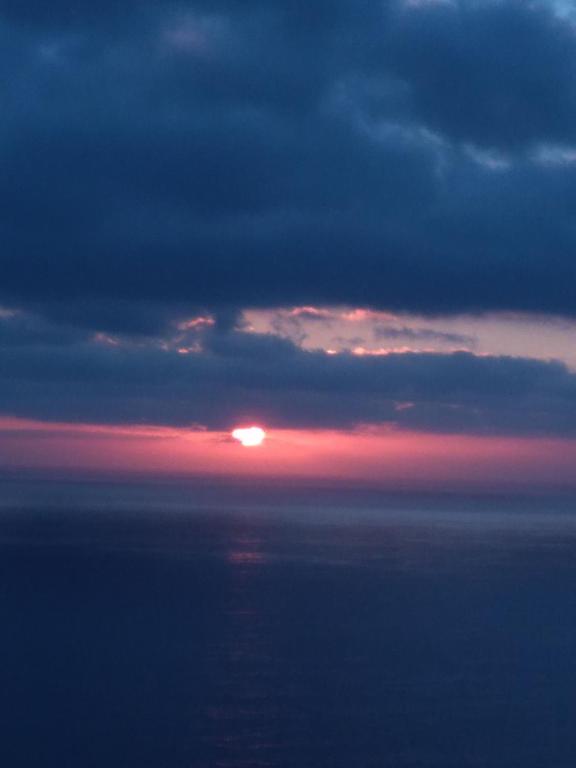 a sunset in the clouds over the ocean at Casa Nea in El Rosario