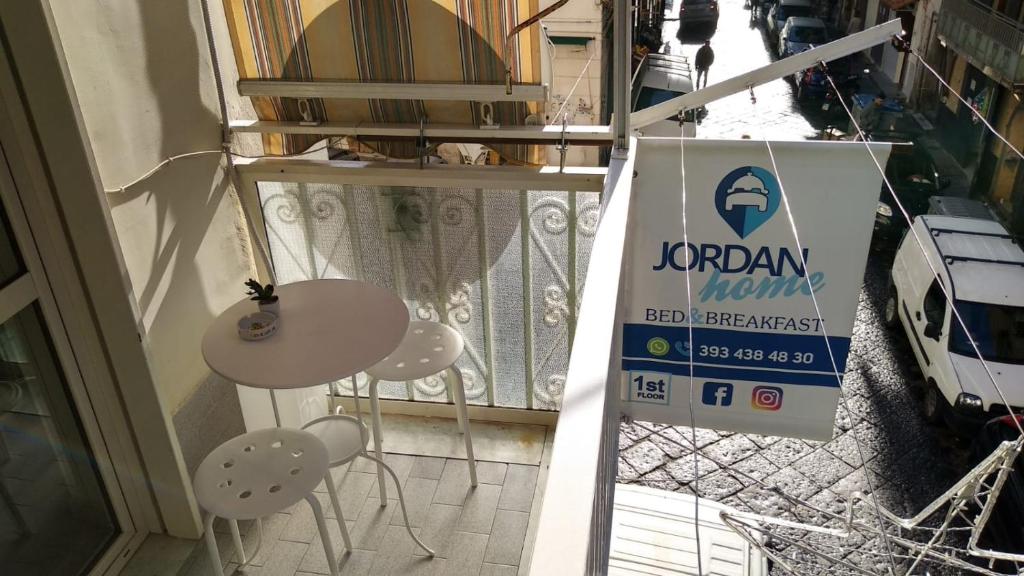 ナポリにあるJordan Homeの看板付きの扉前のテーブルと椅子