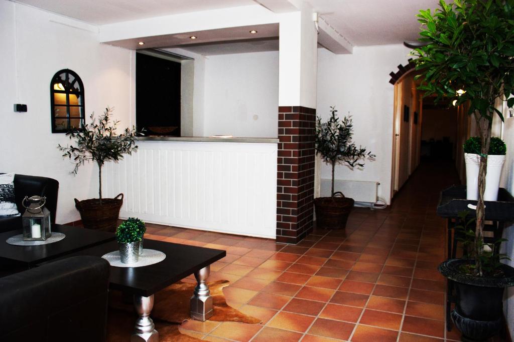 a living room with tables and potted plants at Bed and Breakfast 33 in Ängelholm