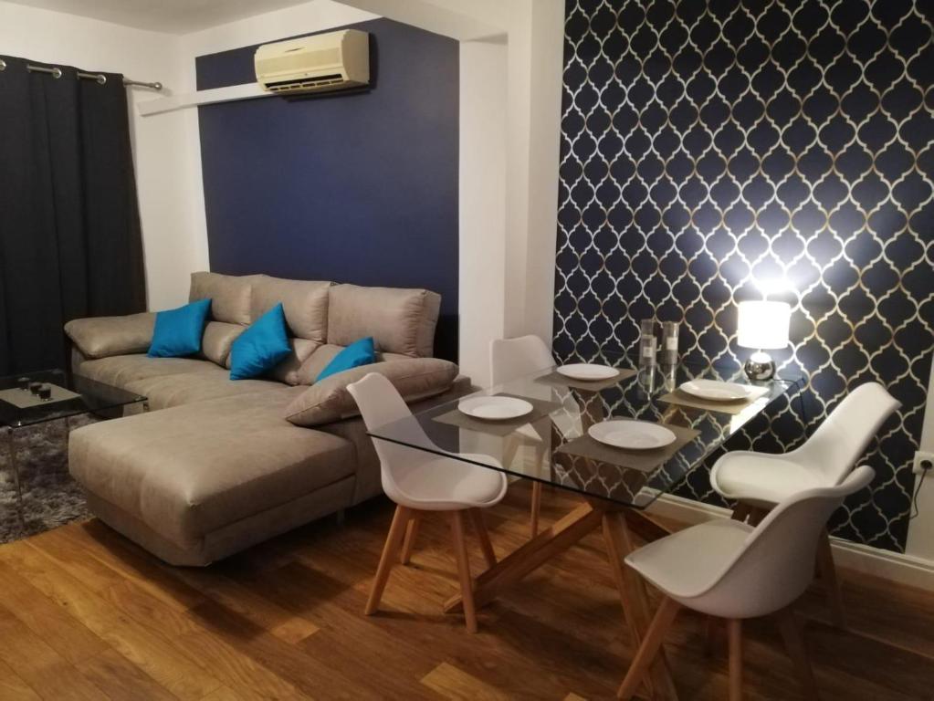 ein Wohnzimmer mit einem Sofa, einem Tisch und Stühlen in der Unterkunft Villahermosa Inn in Castellón de la Plana