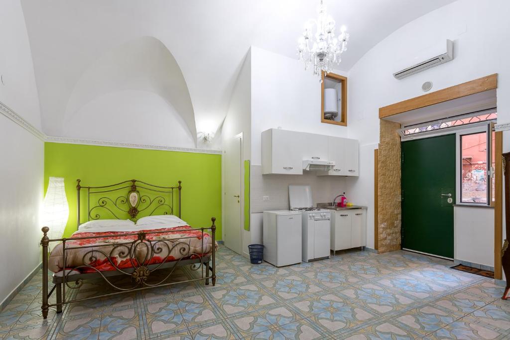 ナポリにあるNaCity Holiday Homeの緑の壁、ベッド付きのベッドルーム1室