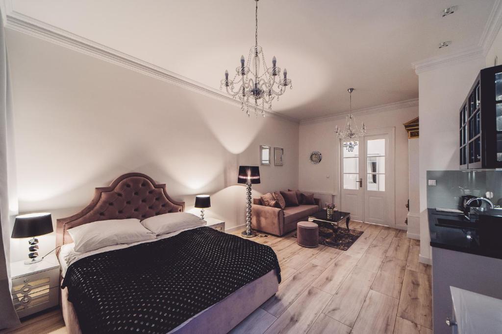 sypialnia z dużym łóżkiem i kanapą w obiekcie Glam Apartments w Toruniu