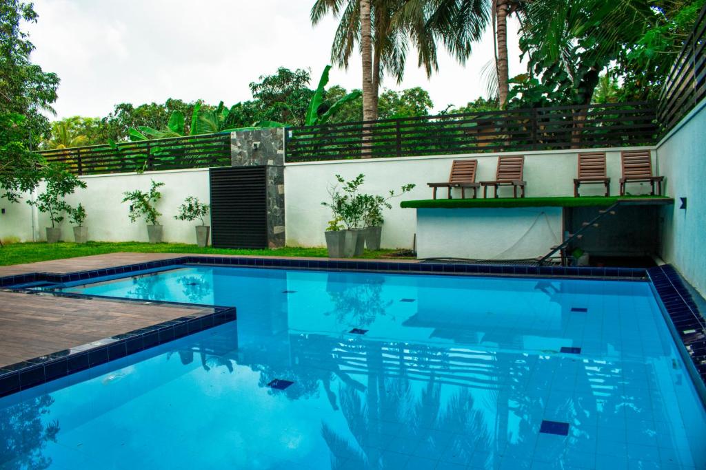 une piscine avec deux chaises et un bâtiment dans l'établissement Hotel Bella Vista, à Anurâdhapura