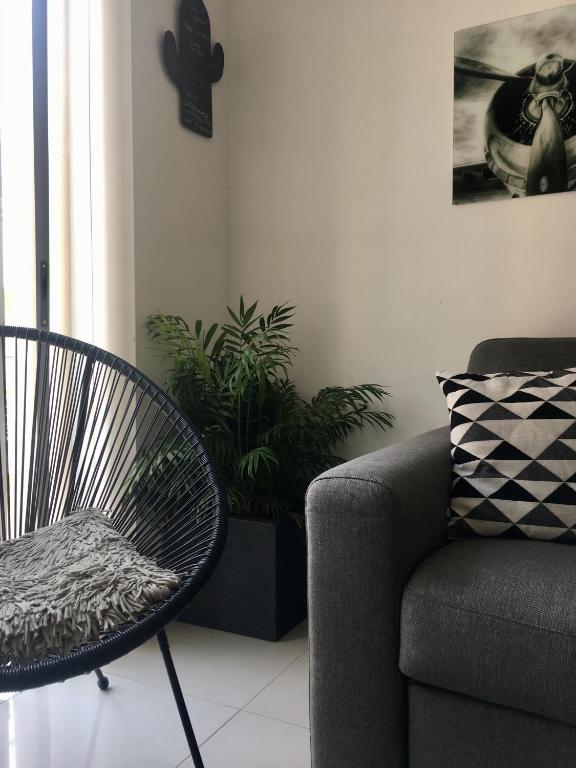 スリーマにあるSimons Apartments minutes away from Balluta Bay and St Juliansのリビングルーム(椅子、ソファ付)