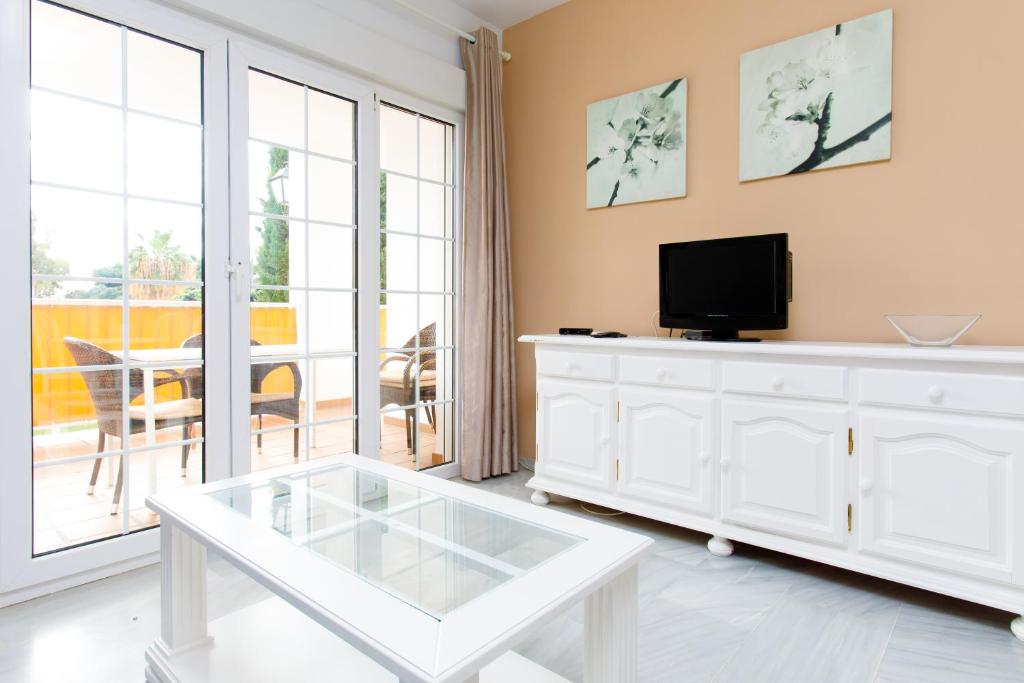 a living room with a tv and a white dresser at AT Almoraide Rooms Suites in Nerja