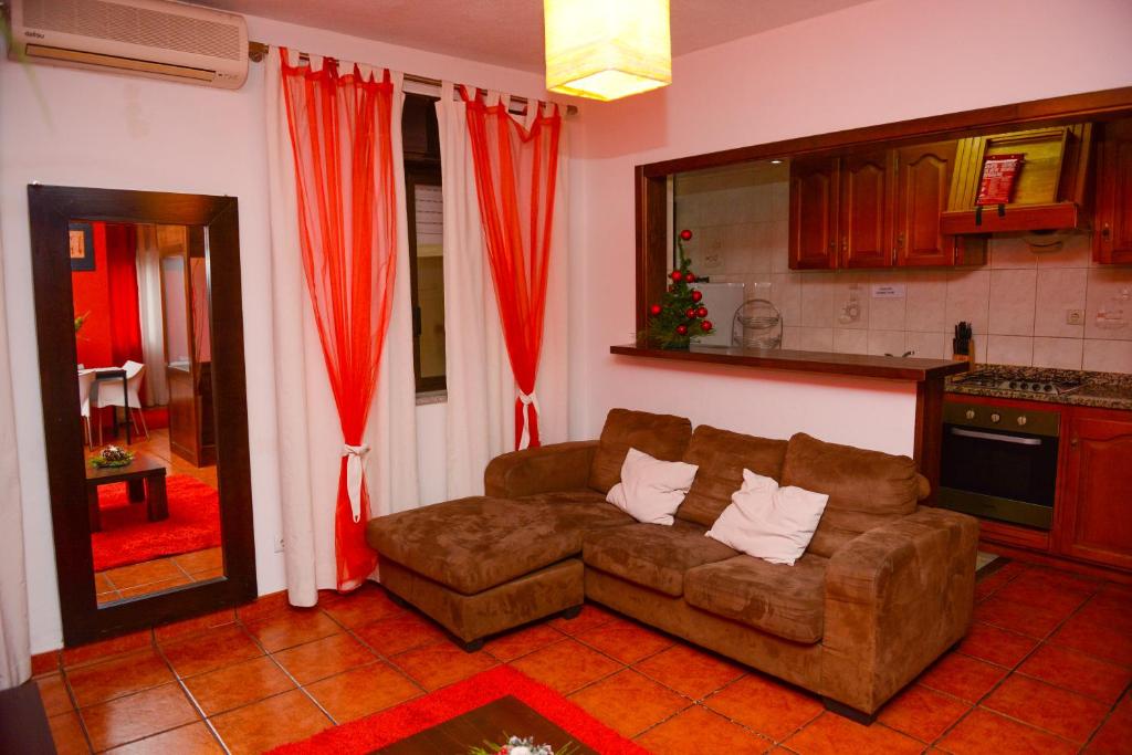 a living room with a couch and red curtains at SEIA Alojamentos Leitao in Seia