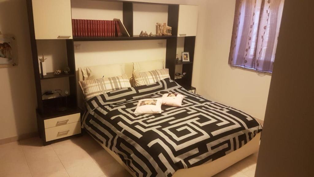 una camera da letto con un letto con un piumone bianco e nero di Alma a Porto Torres