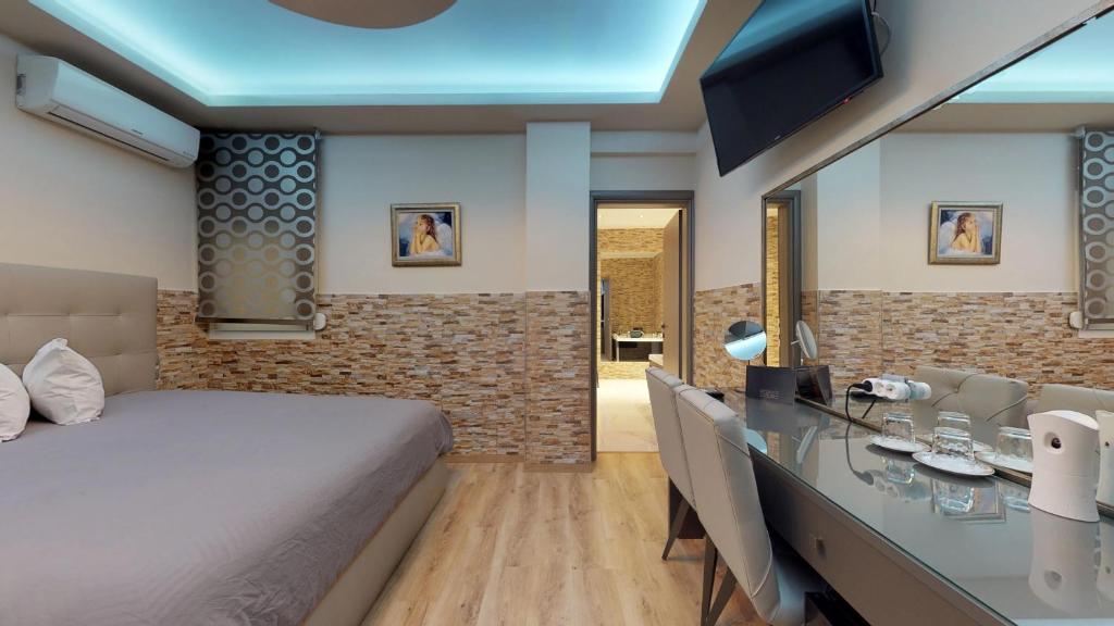 sypialnia z łóżkiem i biurkiem z telewizorem w obiekcie Luxury Living Apartments and Spa w Salonikach