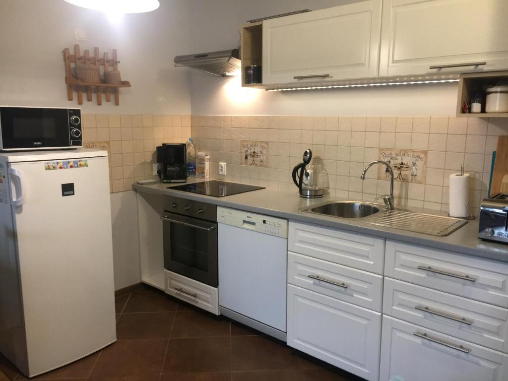 een keuken met een witte koelkast en een wastafel bij livingROOM_Wroc_Mosiężna in Wrocław