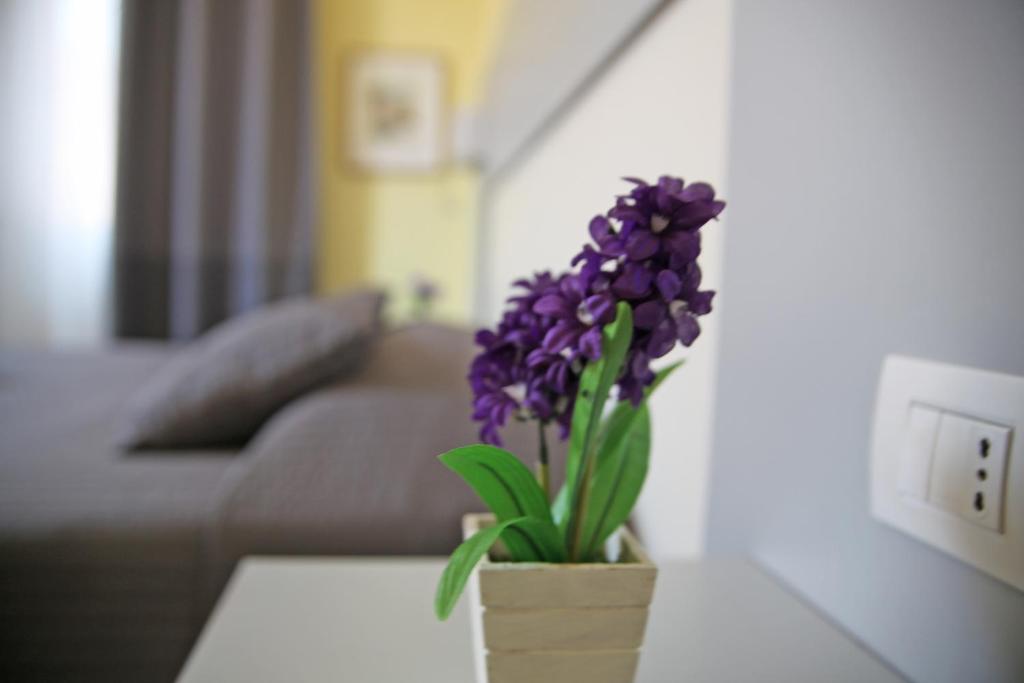 un jarrón de flores púrpuras sentado en una mesa en Seawall Holiday Home, en Salerno