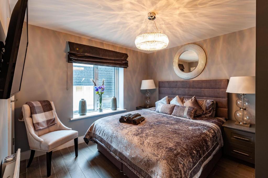 a bedroom with a large bed and a chair at The Town House,Kinsale,in town centre, Exquisite holiday homes, sleeps 16 in Kinsale