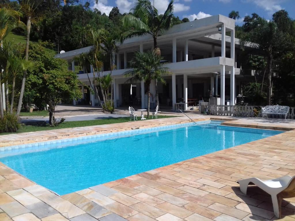 a swimming pool in front of a house at SÍTIO FLOR DE LYS in Jarinu