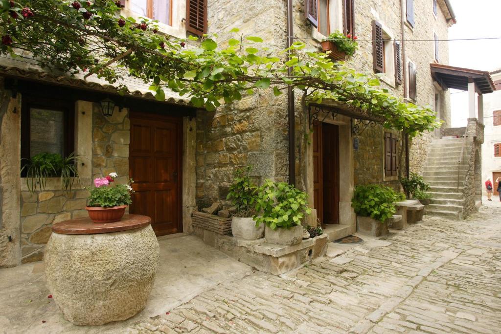 a stone building with potted plants on a street at Rooms Sara in Grožnjan