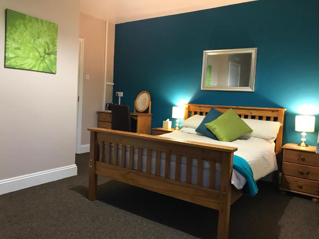 a bedroom with a bed with a blue wall at White Heather Guest House in Mablethorpe