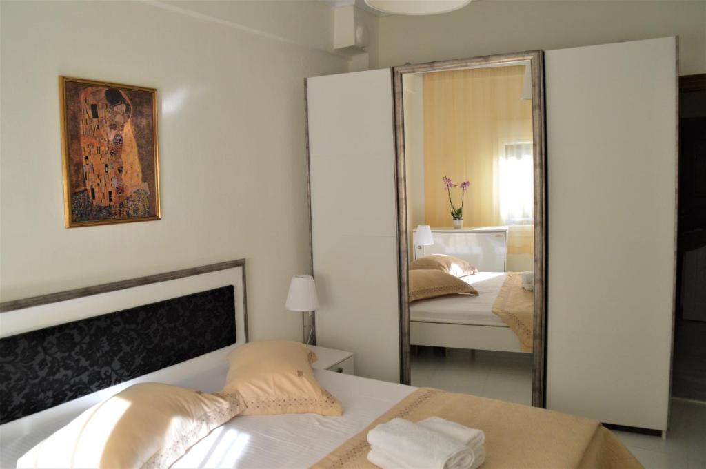 1 Schlafzimmer mit 2 Betten und einem großen Spiegel in der Unterkunft Aigaiou House in Thessaloniki