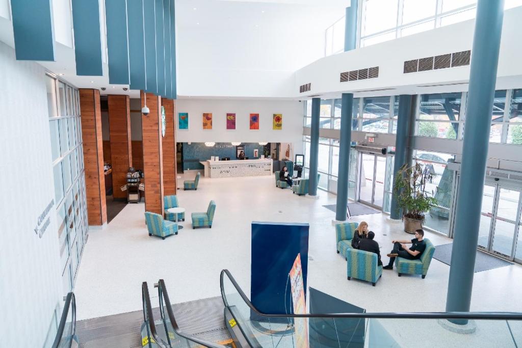 two people sitting in chairs in the lobby of a building at Coast Hotel & Convention Centre in Langley